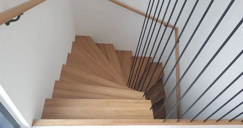 Moderní dřevěné schodiště s kovovými zábradlím.