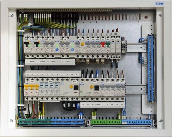 Vnitřní sestava elektrického rozvaděče s pojistkami a vodiči.