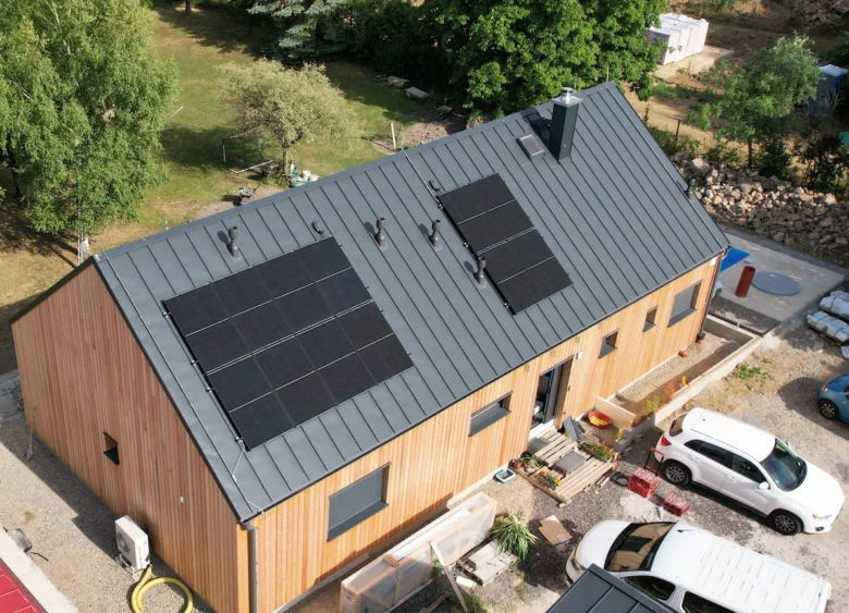 Dům s fotovoltaickými panely na střeji pro solární elektrárnu.
