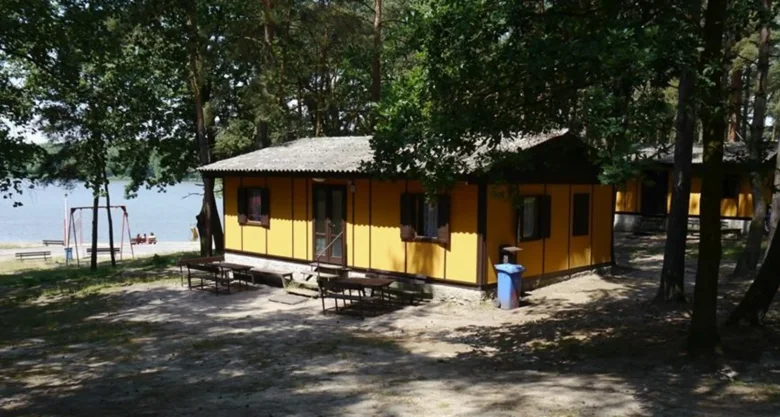 Žluté chaty v lese u jezera na kempu Holany