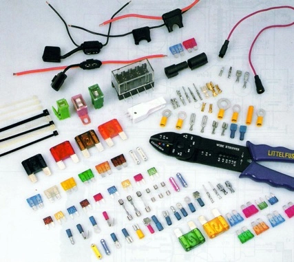 Sada elektrických pojistek, konektorů a nástrojů pro instalace.