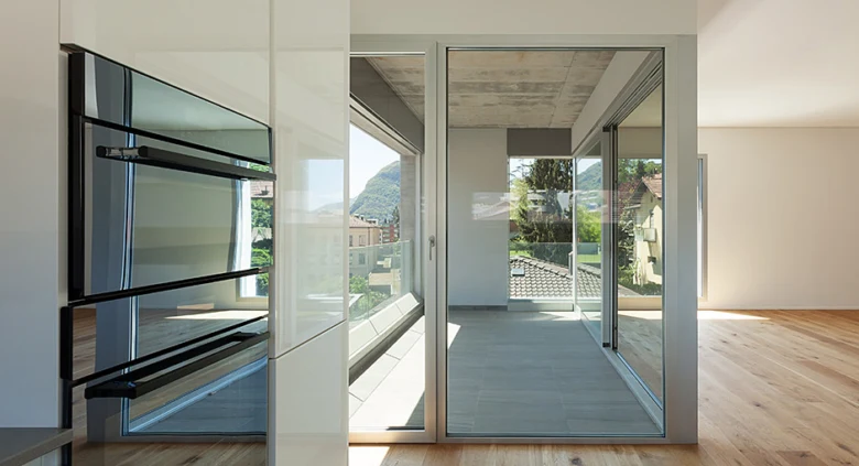 Moderní skleněné dveře na balkon s výhledem do terasy.