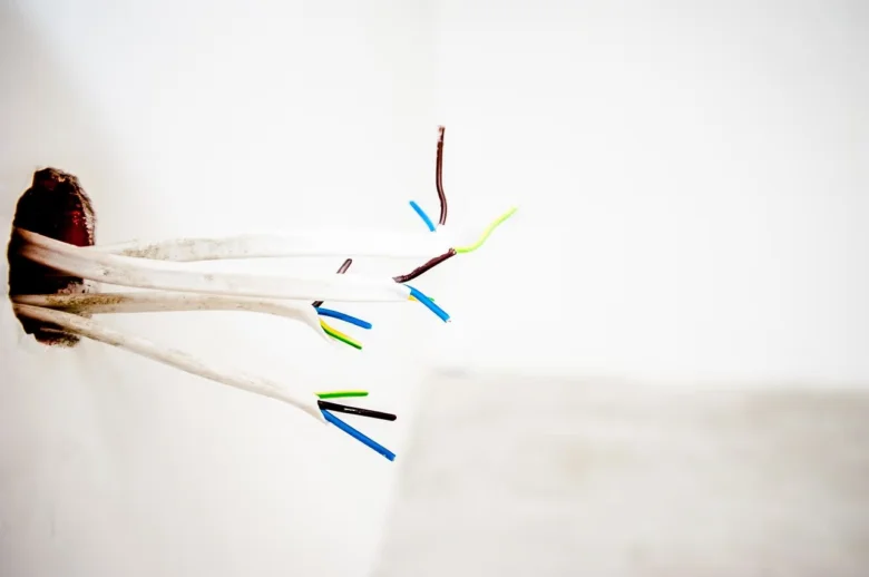 Odkryté elektrické vodiče v otvoru stěny pro instalaci vypínače.