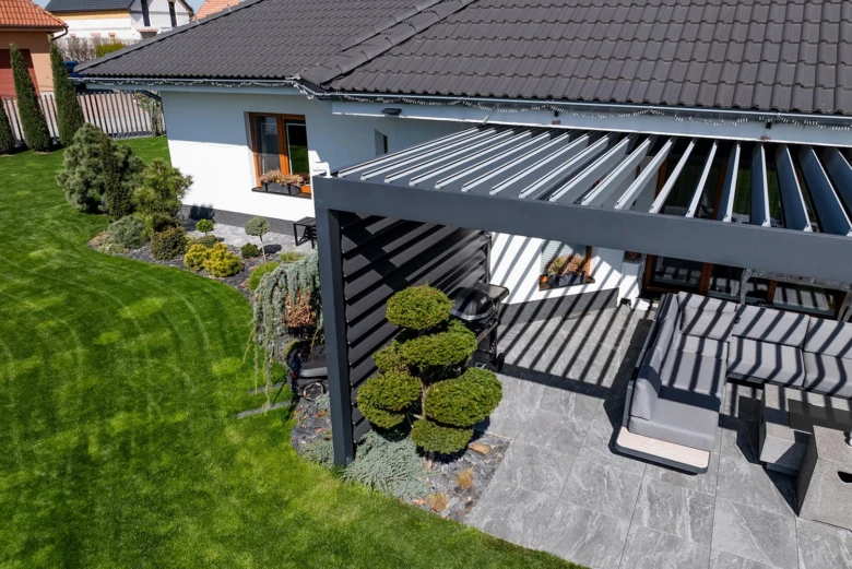 Moderní střešní pergola s sedacím místem u rodinného domu.