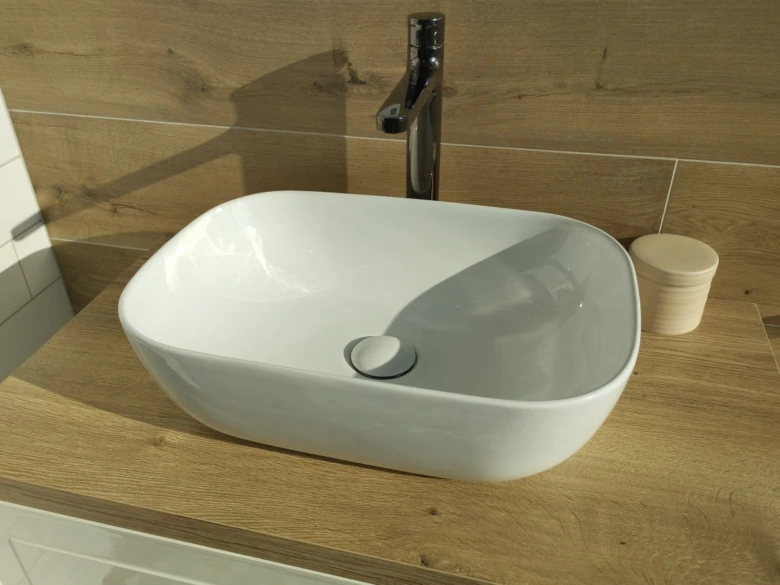 White vessel sink on wood countertop