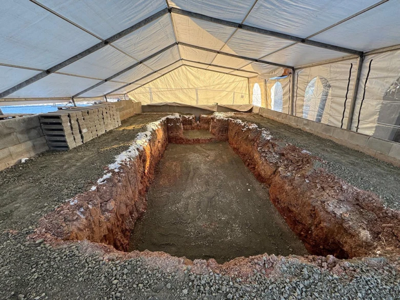 Zasazený bazén v příkopu pod plachtou během instalace