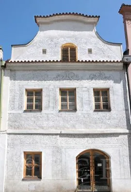 Bílá fasáda domu se vzory ve technice sgrafita po rekonstrukci.