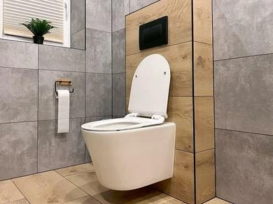 Moderní bílý záchod na zeď v koupelně s dřevěnou panely.