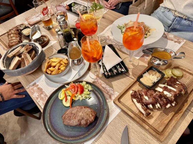 Stůl v restauraci s jídlem, nápoji a saláty.