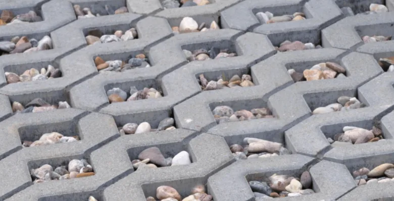 Betonové zatravňovací kostky s kamínky pro propustnost vody.