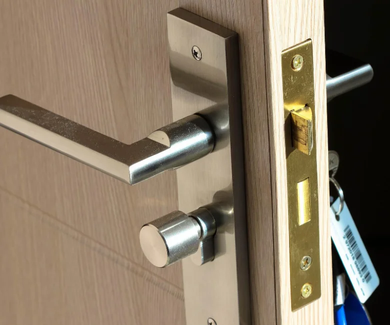 Detailní pohled na zámek dveří s klikou a jazykem pro výměnu.