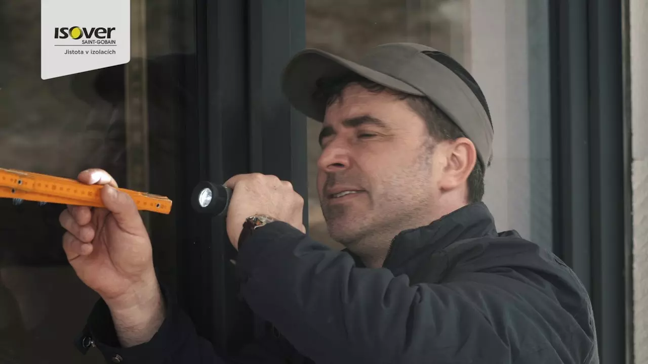 Muž kontroluje kotvicí hmoždinku pro styropor na fasádě.