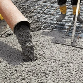 Práce s betonem pro základy: nalévání směsi na ocelovou mříž.