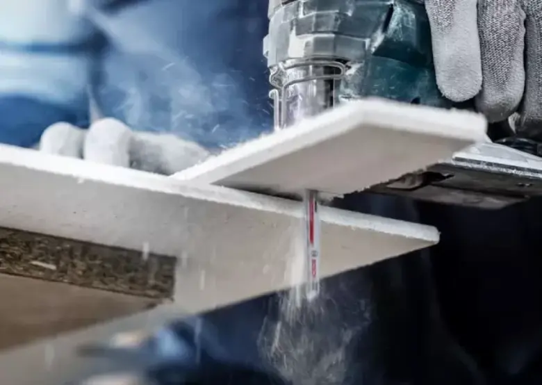Stroj řezá bílý styrofoam s tvorbou prachu.