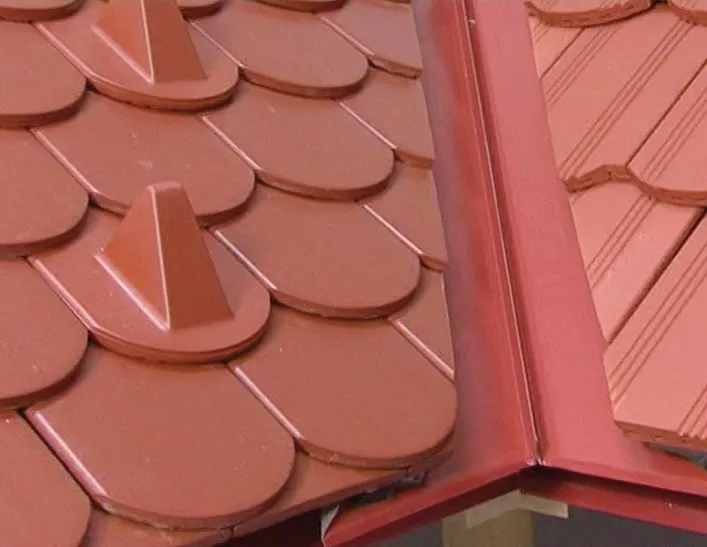 Detail střechy s taškami v úžlabí a kovovým oplechováním.