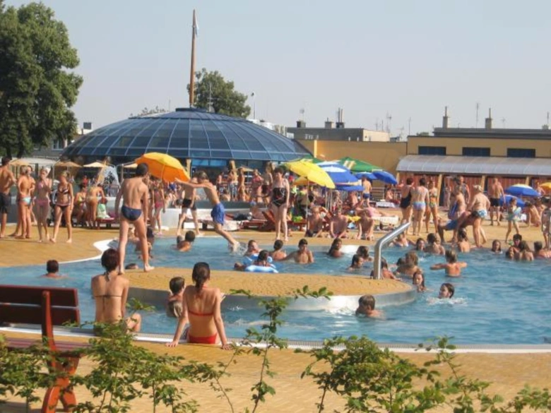 Lidé plavou v bazénu na koupališti v Prostějově.