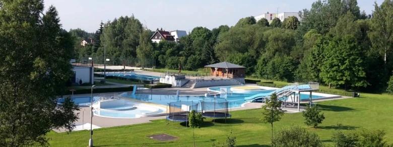 Venkovní bazénová komplex v Havlíčkově Brodě s více plaveckými dráhami a atrakcemi.