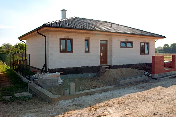 Rodinný dům z porobetonu ve fázi dokončování s viditelnými stěnami.