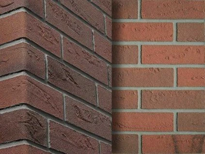 Detail červené cihlové fasády s viditelnými spárkami.