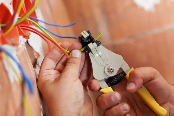 Elektroinženýr stříhá barevné vodiče pro instalaci.