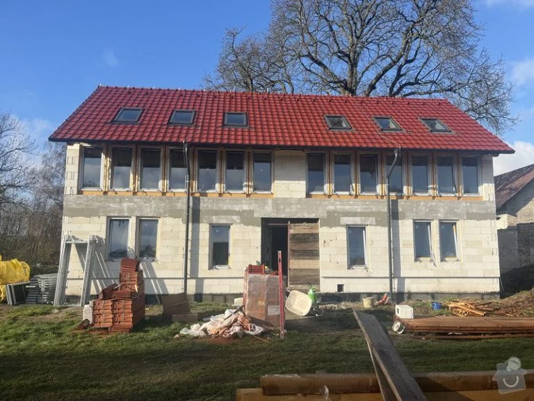 Rodinný dům v hrubé stavbě s novou střechou.