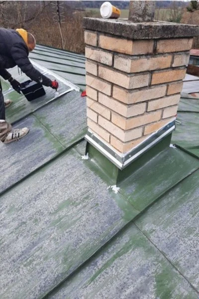 Práce na opravě střechy kolem komína.