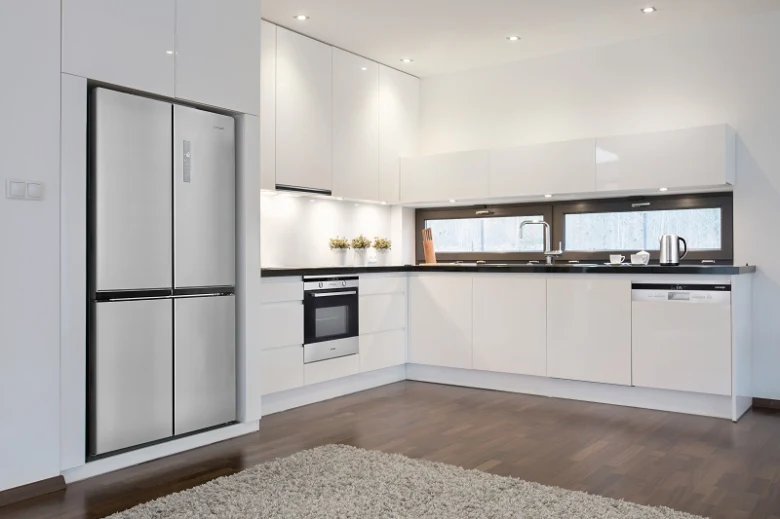 Moderní kuchyň s lednicí v bílém designu pro článek o spotřebě elektřiny.