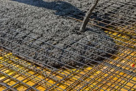 Zelený betonářský výztuž s ocelovou mříží při nalévání betonu.