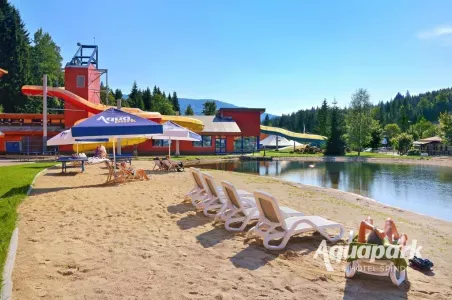 Venkovní aquapark s tobogány a lehátky u bazénu ve Špindlerově Mlýně.