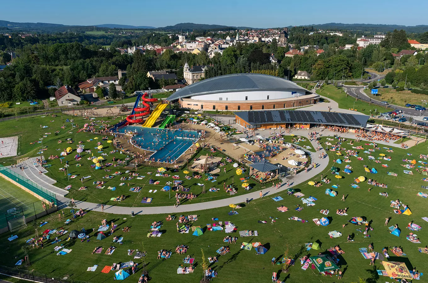 Letní koupaliště s bazény, skluzavkami a občany v Turnově.