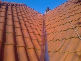 Detailní pohled na úžlabí střechy s červenými taškami.