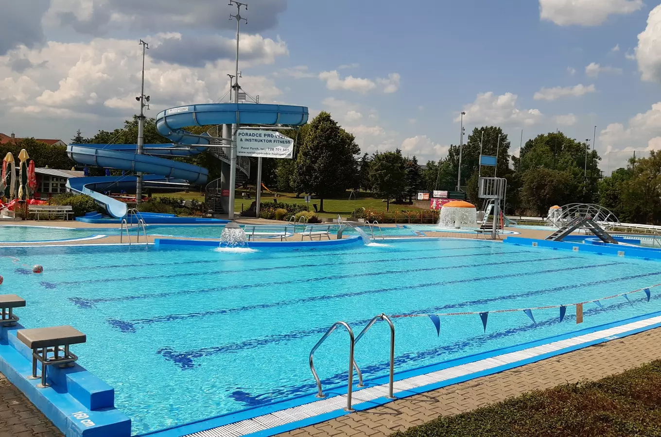 Venkovní bazén s vodními skluzavkami v koupališti Hustopeče.
