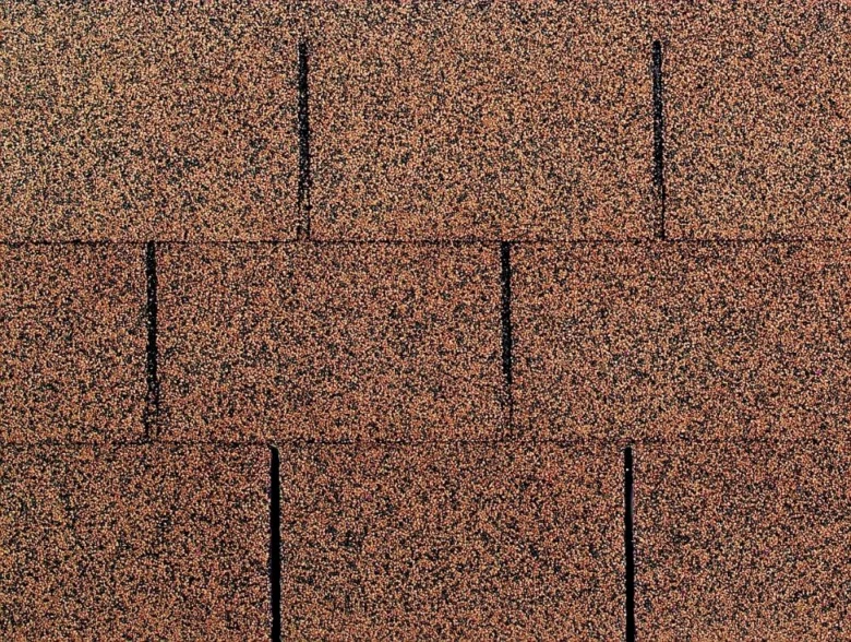 Detailní pohled na asfaltové střešní šindele s granulovanou texturou.