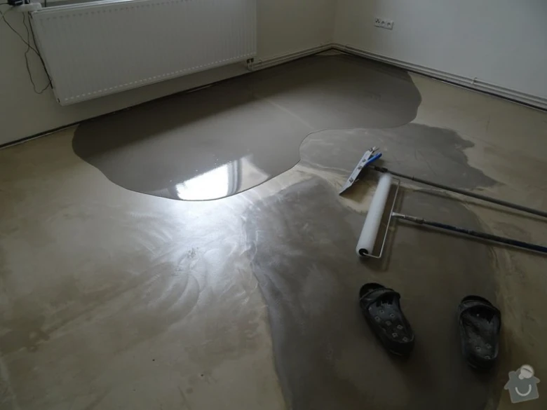 Nálevná podlahová stěrka se rozlévá na betonovou plochu.