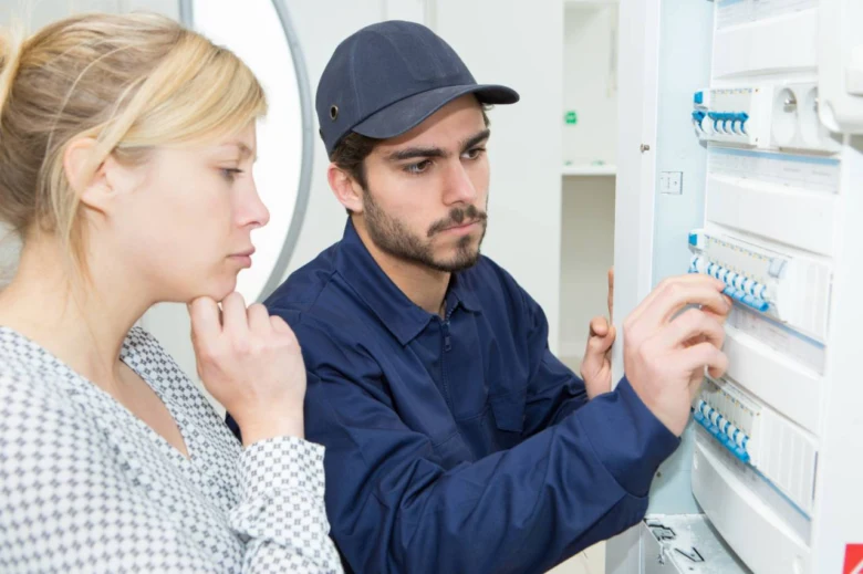 Elektrikář kontroluje jističe v rozvaděči při instalaci.