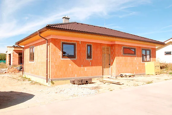 Dům z porobetonu ve fázi stavby s viditelnými okny.