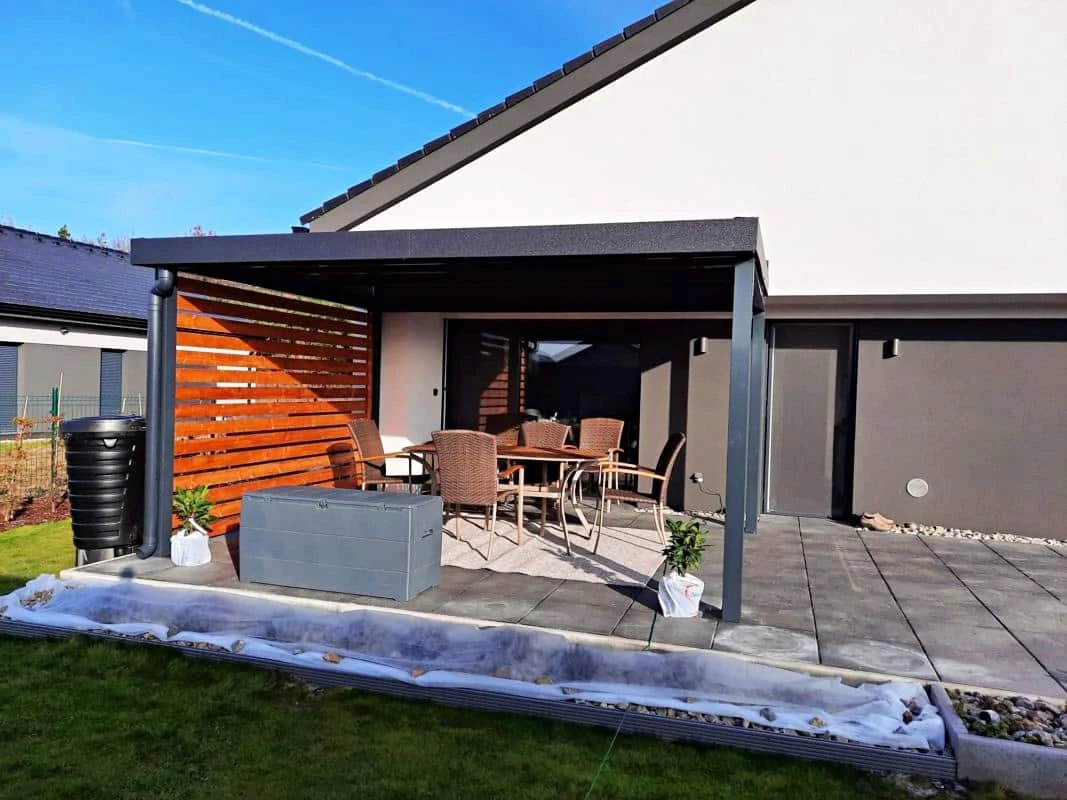 Dřevěná pergola s venkovním posezením na zahradě.
