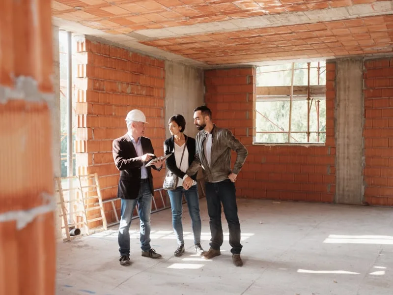 Architekt s klienty diskutuje o rozpočtu hrubé stavby domu.