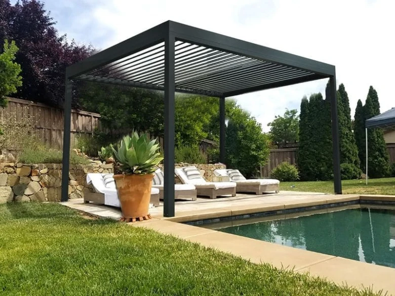 Moderní černá zahradní pergola s lehátky u bazénu.