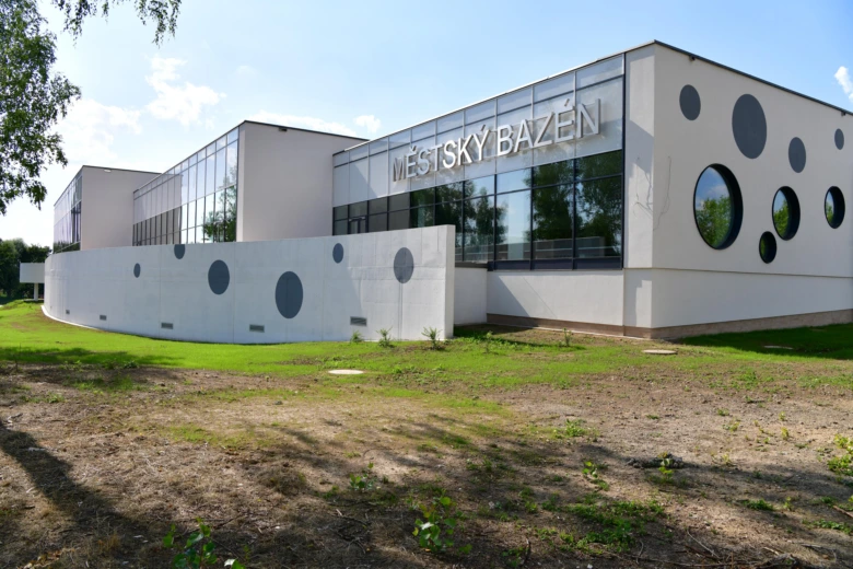 Fotografie krytého městského bazénu v Karviné s okny ve tvaru kruhu.