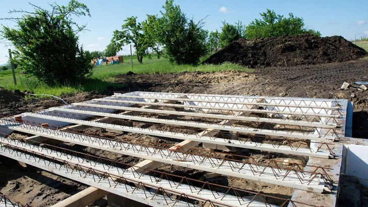 Základová deska s výztuží na staveništi v přírodním prostředí.