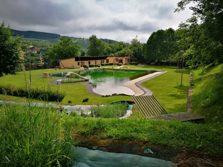 Natural swimming pool with building