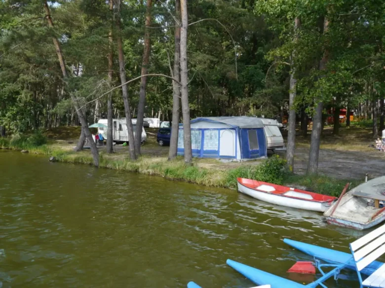 Kemp s plavidly u lesa na jezeře Holany