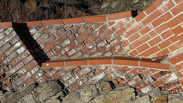 Detail červených dlaždicových obkladů na fasádě budovy.