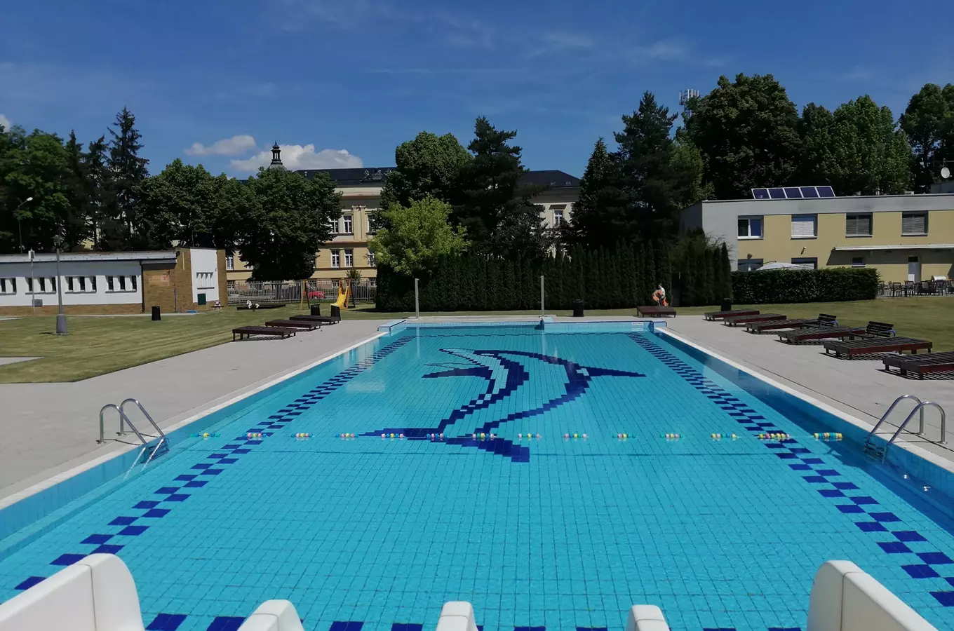 Venkovní bazén ve Svitavách s logem delfína.
