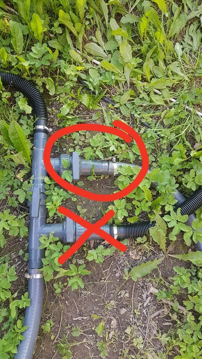 Svépomocný solární ohřev bazénu s potrubím a hadicemi na trávníku.