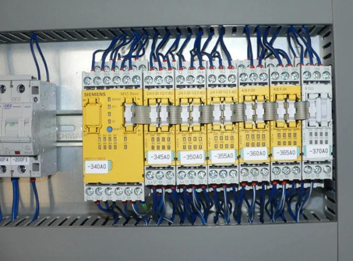 Modul řídicího systému Siemens v elektrickém rozvaděči s modrým kabelováním.