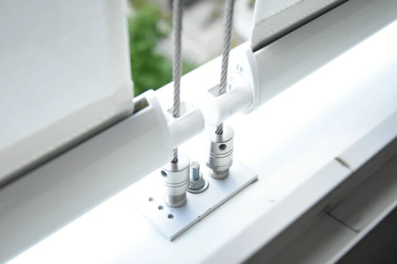 Detailní pohled na mechanismus závěsu pro venkovní roletu.