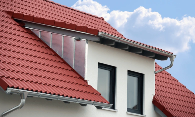 Detailní pohled na konstrukci vikýře s červenou střechou.