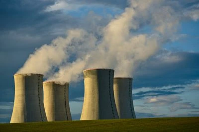 Čtyři chladiče jaderné elektrárny s párou na obloze.
